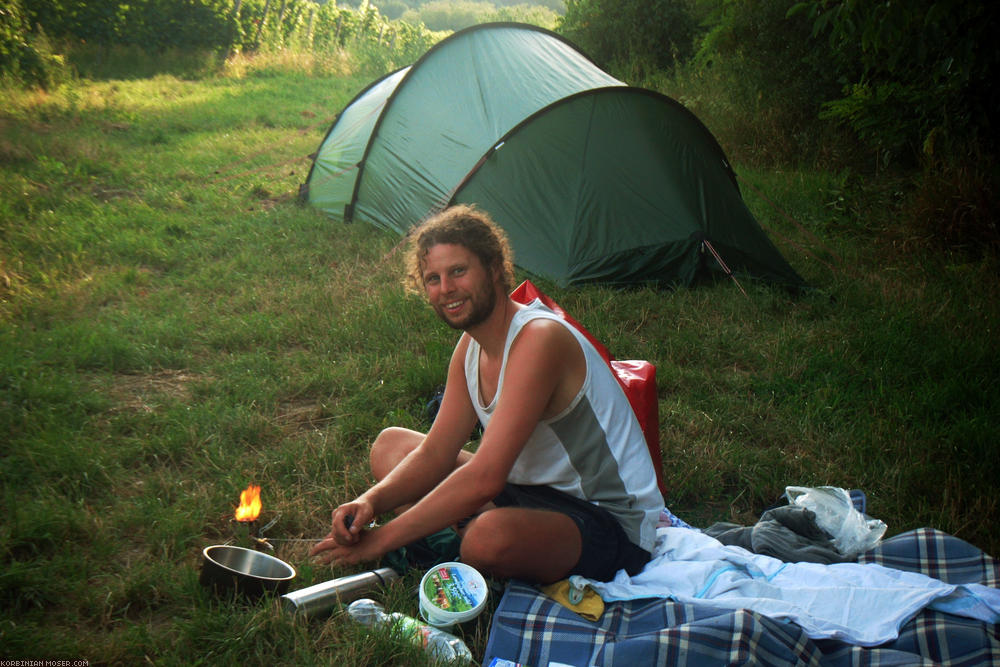 ﻿Camping in the vineyard. Korbinian starts the stove for Mona's bathing water.