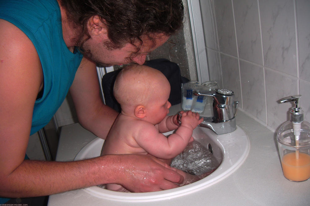 ﻿Neue Bademethode. Wegen des schlechten Wetters, und da wir es uns jetzt leisten können, nächtigen wir in einem Hotel in Hainstadt. Mona findet das Baden im Waschbecken sehr interessant.